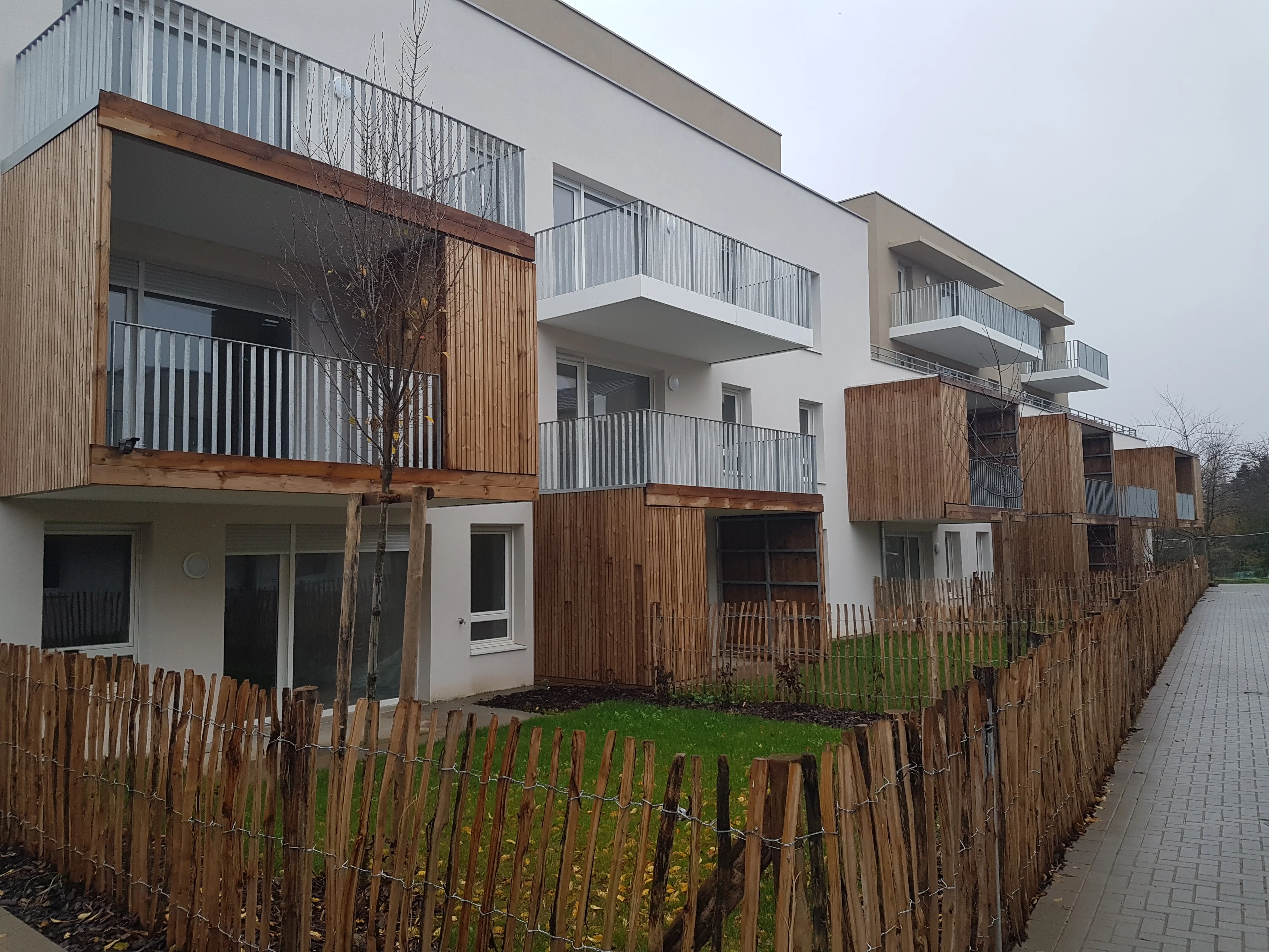 Façade de la résidence avec balcons et rangements bois